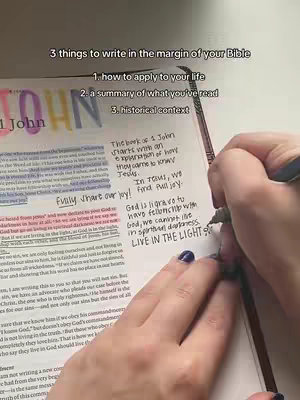 The image shows an open Bible on a table. A hand with a pen is writing notes in the margin of the bible.  The notes are next to highlighted texts with colorful highlighters. The text on the image is in English.