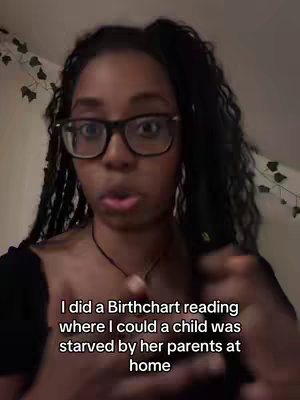 A woman with dark skin wearing glasses is facing the camera and speaking. Text overlay beneath her reads, "I did a Birthchart reading where I could a child was starved by her parents at home."