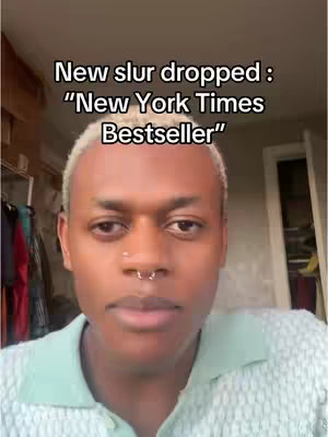 A close-up shot of a person with light skin and short, bleached hair. The person has a nose ring and is wearing a light green collared shirt. The upper portion of a cluttered closet is visible in the background, along with a glimpse of what may be a window. Text overlay at the top.
