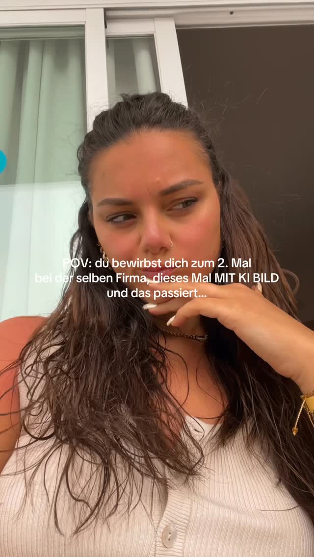 A medium shot of a woman looking concerned with text overlaid on the image. She is wearing a white top and has long, dark hair. The background appears to be an indoor setting with a window visible behind her.