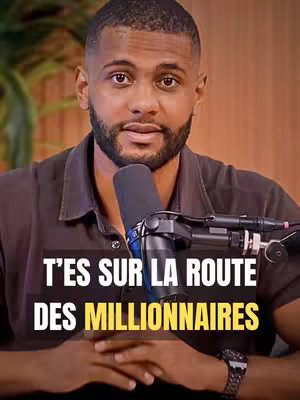A man with a beard is centered, set against a blurred background with a microphone positioned in front of him. Bold, yellow text overlays the image.