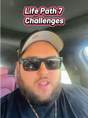 A selfie taken from inside a vehicle. A man with a beard and sunglasses is centered, with text overlaid at the top. The interior of the car, including the seat and side window, is visible in the background.