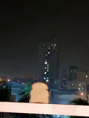 A slice of bread is set in front of the cityscape at night.