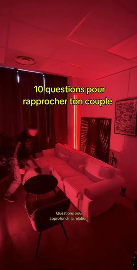 The cover image is a vertical shot of a room with red lighting. A man in a black jacket and pants appears to be entering the room from the left, looking towards a white sofa. In the background, there's a red light strip and a dark curtain. Text overlays inform the viewer of the subject matter in the video.