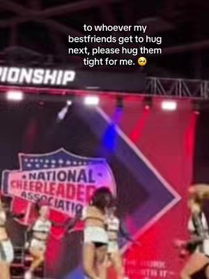 A performance stage is the focus of the image, with a large banner that says "CHAMPIONSHIP" above. Cheerleaders in uniform perform on stage. Added text overlay reads: "to whoever my bestfriends get to hug next, please hug them…"
