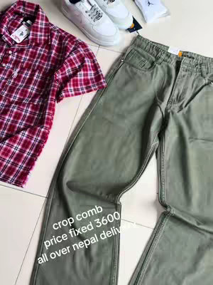 The image displays a flat lay of fashion items. There is a red and white checkered short-sleeved shirt, a pair of green pants, white sneakers, and socks. Text overlays the pants, with information about the product.