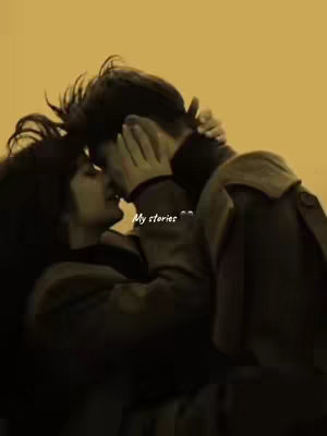 A romantic, sepia-toned image of a couple embracing and kissing. The man has dark hair. The woman's hair is dark. The lighting is soft and suggestive, with the image having a vintage feel.