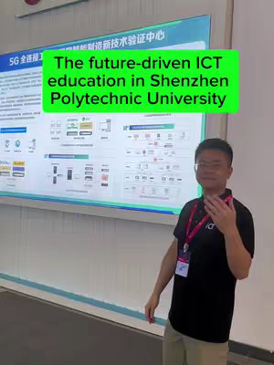 The cover image features a man standing in front of a large display board. The man is wearing glasses, a black polo shirt, and a lanyard around his neck. The board behind him has text and diagrams regarding 5G technology and education at Shenzhen Polytechnic University, with a green overlay text that says 'The future-driven ICT education in Shenzhen Polytechnic University'. The overall composition is well-lit, suggesting an informational or promotional video.