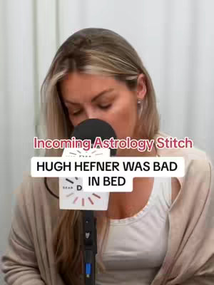 A blonde woman with light skin is speaking into a microphone during what appears to be a podcast or interview. Text overlays appear on the screen with words like "Incoming Astrology Stitch" and "Hugh Hefner was bad in bed".