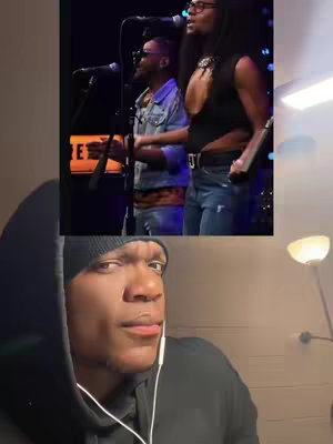 The cover image is a split screen. The top portion shows a performance scene with two people singing into microphones on a stage. The bottom half is a close-up of a Black man with a thoughtful expression, wearing a black beanie and a black hoodie.