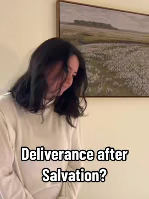 The cover image features a person, primarily a woman, in a casual setting. She is wearing a neutral-colored top and has dark hair that partially obscures her face. The background includes a painting in a wooden frame. Text overlayed on the image reads: Deliverance after Salvation?