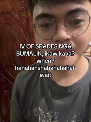A selfie-style image of a young man in glasses, with overlaid text. The man fills most of the frame and is centered, cropped from the shoulders up. The background is blurred, but seems to be a reddish-brown wall. The man wears a dark gray shirt. The text overlay, written in a white, sans-serif font, poses a question about the band IV of Spades.
