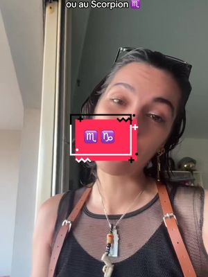 A woman is looking at the camera with a filter that has 2 sign icons behind. She's wearing a black spaghetti strap top and brown shoulder straps, with earrings and a necklace. The background appears to be blurry with some light coming in.