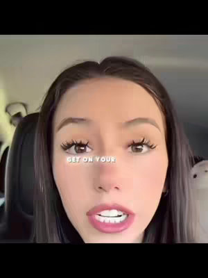 A close-up shot of a person's face with a text overlay. The person has long dark hair and is looking directly at the camera with open mouth. The text overlay says "GET ON YOUR". The background seems to be inside a car.