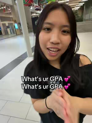 A young woman with long dark hair smiles at the camera in an indoor setting. Text overlays the image asking "What's ur GPA?" twice, along with pink heart emojis.