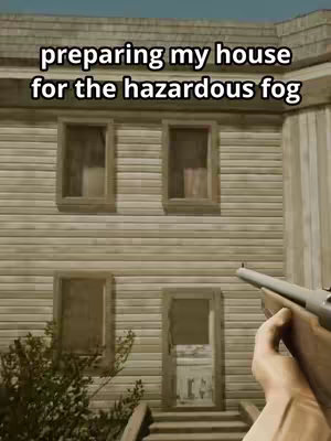 A first-person perspective shows a worn, two-story house. The house has a weathered wooden exterior with several windows and a door. The scene is filmed with a handheld camera perspective and the hand with gun is the only human presence.