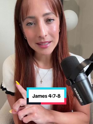 The cover image is a selfie-style shot of a woman. She is fair-skinned with long reddish-brown hair and bangs. Her eyes are visible and her lipstick is apparent. She is wearing a white ribbed shirt. In her left hand, she is holding her finger up as if she is pointing something out. Behind her is a microphone. A rectangle at the bottom of the image contains the text "James 4:7-8." The background appears to be an undetailed wall, with a circular object.