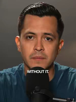 A medium shot shows a man facing the camera, with text overlayed below him. The man is of mixed ethnicity with closely cropped dark hair and a neutral expression. He wears a dark colored t-shirt or sweater. Behind him is a gradient background.