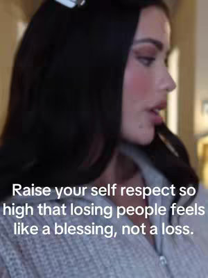 A woman with dark hair and makeup is shown in a close-up. The background is blurred, and the focus is on her face and the text overlaid on the image.