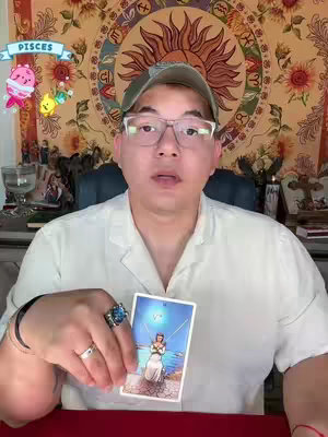 The cover image shows a man in glasses and a cap holding a tarot card. A background tapestry and additional decorative elements are also visible. The scene is lit with even, natural light.