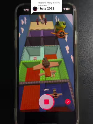 The cover image shows a phone displaying a level from a Roblox game inspired by the Squid Game series. The game level is set up as a series of colored platforms in a corridor, with various characters placed on the platforms. The phone screen showing the game is framed within the phone, with a black background. On the top right of the screen a comment shows "I hate 2025". There is the recording button from the software.