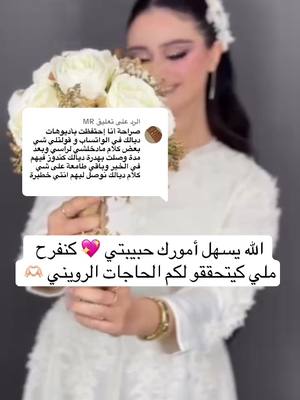 A person, holding a bouquet of white roses, is smiling toward the camera. The person is wearing a white outfit and a white floral headpiece. A text overlay appears above their head and at the bottom.