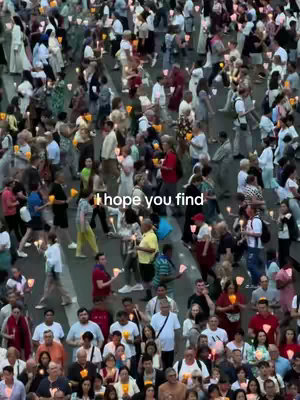 An aerial view of a large crowd of people walking on a paved surface. They are holding small, lit candles. Text overlayed on the image says, "I hope you find."