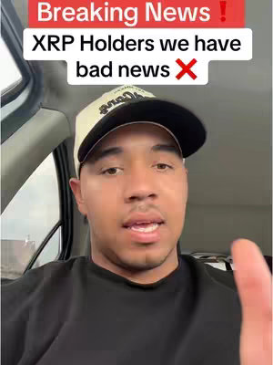 A man is speaking to the camera from inside a car. Above him is a text overlay in a red box that reads, 'Breaking News!'. Below this, is the text 'XRP Holders we have bad news'. The man is wearing a black shirt and a black and white baseball cap. The background is blurred.
