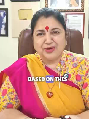 A woman with dark hair and a red bindi wears a yellow and pink outfit. Text in a blue rectangular box reads "BASED ON THIS". The background has framed images on the wall.