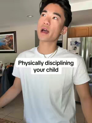A young man stands indoors in front of a kitchen, looking up with an open mouth. The background includes kitchen cabinets and a refrigerator. Written overlay on the image reads, 'Physically disciplining your child'.