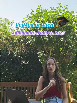 The image features a young woman sitting on a wooden bench in front of a dense green hedge. She is wearing a red top and jeans, with long, flowing hair. Overlaid on the image is text in green and yellow fonts, with a graduation cap icon, and the text 'VetMed in Wien Aufnahmeverfahren 2025.' A laptop is open on the bench in front of her. The overall scene is bright and outdoors, with a blue sky visible.