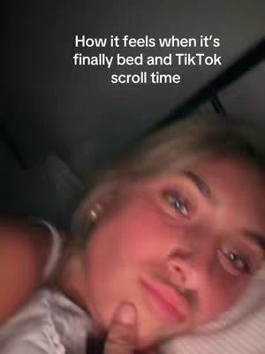 A selfie-style shot of a young woman lying in bed, illuminated by soft lighting. The background is dark, suggesting a bedroom setting. The woman has light-colored hair and is looking towards the camera with a slightly relaxed expression. Text overlays provide the hook for the video.