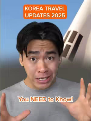A man with dark hair and a grey t-shirt is against a blue sky and the flag of South Korea, with an orange rectangular box at the top of the frame that reads "KOREA TRAVEL UPDATES 2025", and another orange rectangular box at the bottom of the frame that reads "You NEED to Know!".