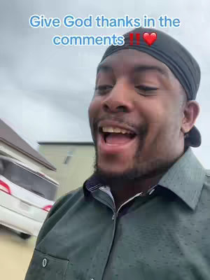 A man with a head-covering and button-down shirt is captured from the chest up, outdoors. He has a big smile, open mouth, and appears to be speaking towards the camera with an excited expression. The text overlay encourages viewers to share sentiments in the comments. The background includes a house and overcast sky.