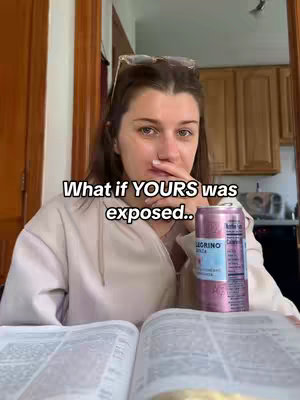 A woman sits at a table with a book open in front of her, a can of San Pellegrino is on the right-hand side. She has her finger up near her mouth, and there is text overlayed on the image.