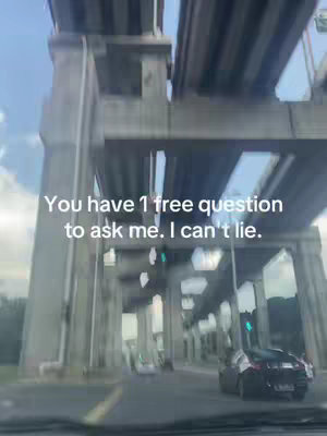 A view from inside a vehicle moving along under a highway overpass. The overpass consists of large concrete supports and a multi-lane structure. Text overlayed on the image states "You have 1 free question to ask me. I can't lie."