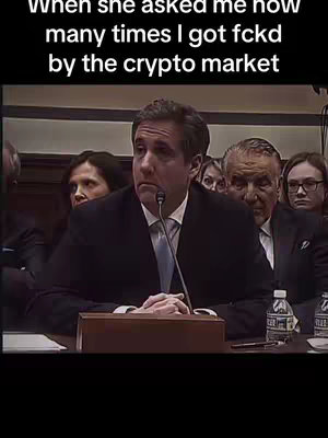The image is a screenshot of a man at a table, with a serious expression on his face. There are other people in the background behind him. Text overlayed on the image.
