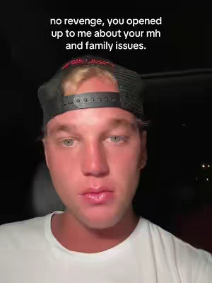 A close-up shot of a young man wearing a black hat and a white t-shirt, set against a dark background. The man is looking directly at the camera with a serious expression. Text overlayed on the image reads, 'no revenge, you opened up to me about your mh and family issues.'
