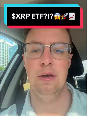 A man with glasses is sitting in a car. There is overlay text on the image above the man's face. Behind the man, you can see a cityscape.