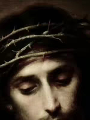A close-up shot depicting the face of a man, likely Jesus, with his eyes closed and wearing a crown of thorns. The image is highly contrasted, with a focus on the central figure's features and the texture of the crown. The lighting creates a somber and reflective atmosphere.