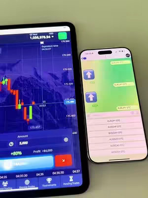The image showcases two mobile devices side by side against a neutral background. On the left, a tablet displays a financial trading interface with a complex chart and numerical data in shades of blue, green, and red. The tablet screen has a black frame. To the right, a smartphone displays a messaging app with a green background and numerous white text strings. The phone's screen is clean, with a camera at the top of the screen. The overall composition is framed from a top-down perspective, focusing on the screens' contrasting details.