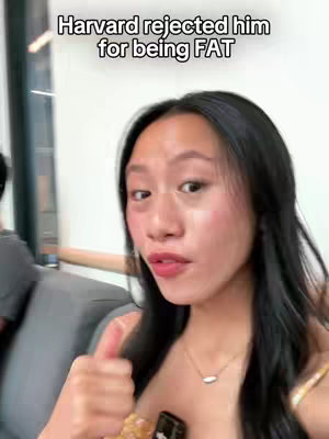 A selfie-style video cover image featuring a young woman giving a thumbs up. She has long, dark hair and is wearing a top with visible straps. She has a necklace, and her lips are a bright red. The background is slightly blurred, suggesting an indoor setting.  Text overlays at the top of the image.
