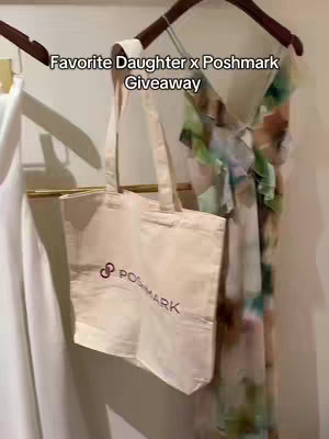 The image shows a clothing rack with a white dress on the left, a cream-colored tote bag with the Poshmark logo in the center, and a floral dress on the right. The text overlay reads, 'Favorite Daughter x Poshmark Giveaway.' The lighting is bright, and the rack is set against a neutral wall.