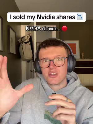 A man with glasses and headphones is speaking to the camera, with text overlays indicating stock market news. The background features an indoor setting with visible windows and furniture.
