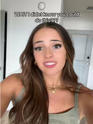 A young woman with long, light brown hair looks directly at the viewer with a slight smile. She wears a light green tank top and a necklace with a star pendant. The background includes a doorway and parts of a room decorated in neutral colors.