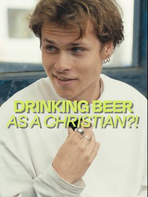 A young man smiles, holding a hand near his mouth, with text overlayed in a bold, eye-catching font: 'DRINKING BEER AS A CHRISTIAN?!'
