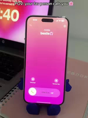 The cover image showcases a smartphone with a pink gradient screen displaying a phone call interface. The screen is mounted on a blue phone stand, against a background with a laptop with a pink screen and a pink notepad.