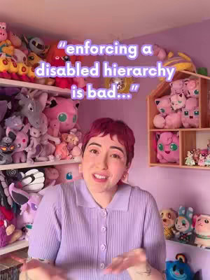 A person with short red hair is presenting in front of a background of plush toys, saying, "enforcing a disabled hierarchy is bad..." The person is wearing a purple shirt. The overall composition is framed to include shelves and display cases filled with the toys.