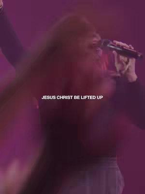 A blurred, vertical image with a person holding a microphone. The background is a gradient of purple and pink, and text overlays the scene. The person appears to be singing or speaking.