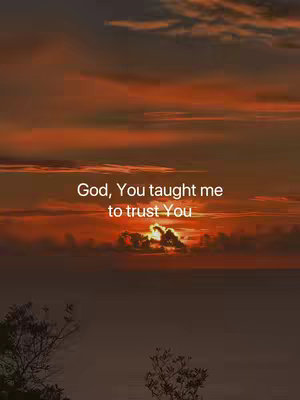 An image of a sunset with dark orange and red hues dominating the sky. Clouds are visible, and at the bottom of the image there are blurred silhouettes of trees. In the center, white text reads 'God, You taught me to trust You'.